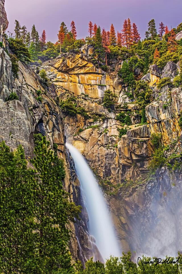 The Cascades (also known as Cascade Falls) plunges down the granite cliffs of into Merced Canyon at sunset. 