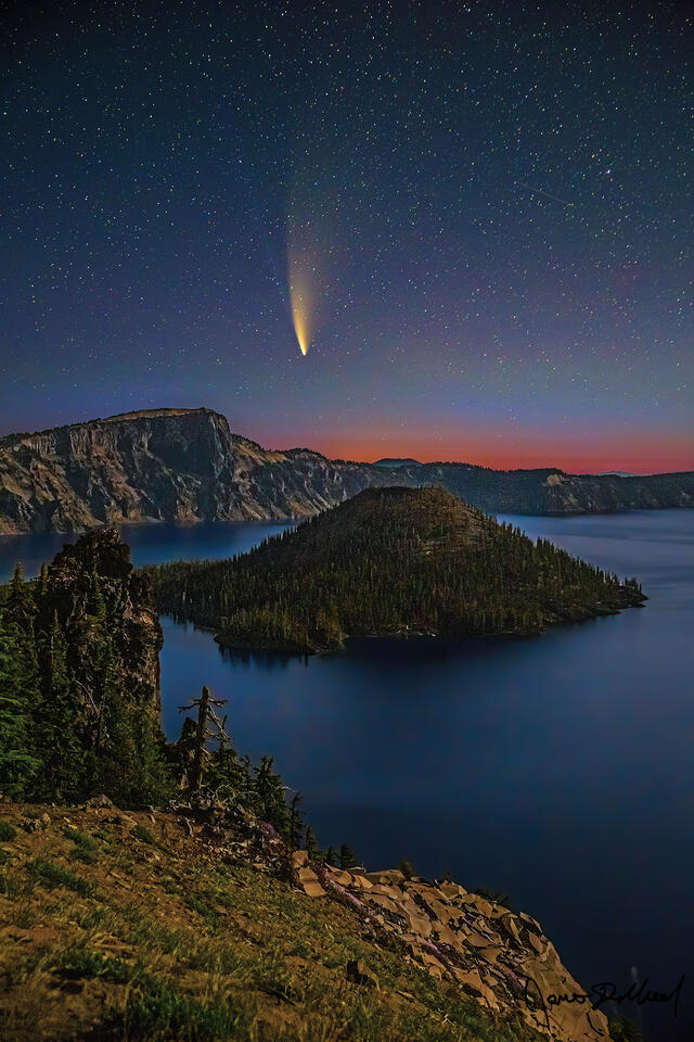Faint aurora airglow rises over Crater Lake and Wizard Island as Comet NEOWISE streaks through the night sky above one of Oregon’s most iconic landscapes.