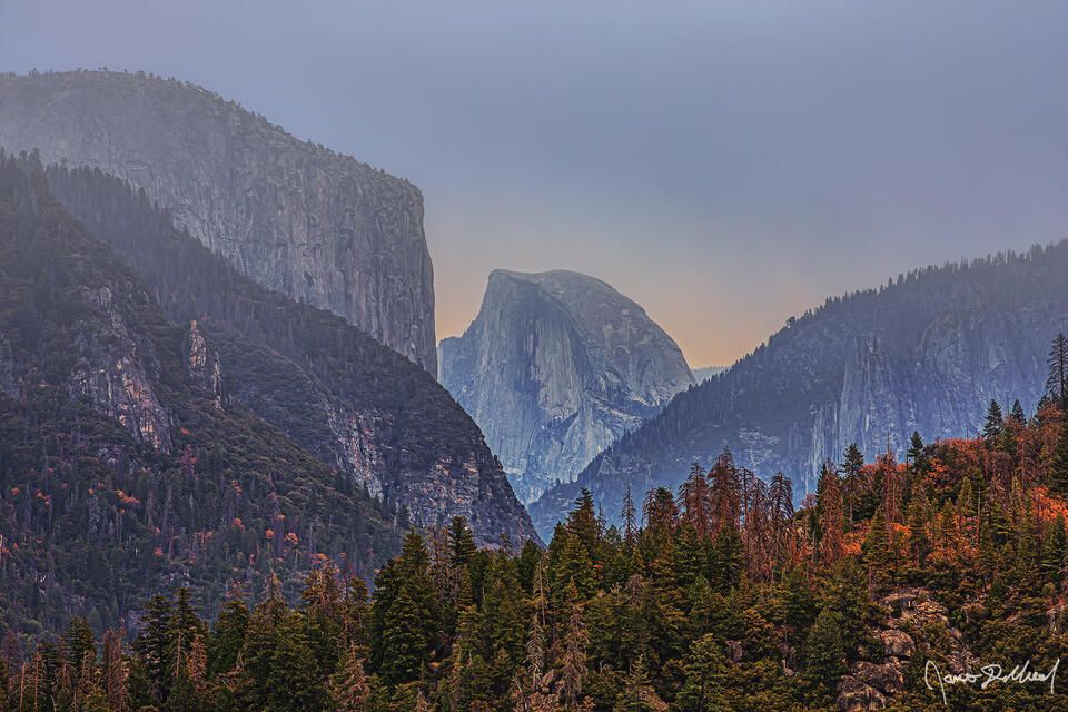 Fog from a fast approaching winter storm envelopes Half Dome and El Capitan as the rising Full Moon illuminates the cloud cover in the skies behind Half Dome
