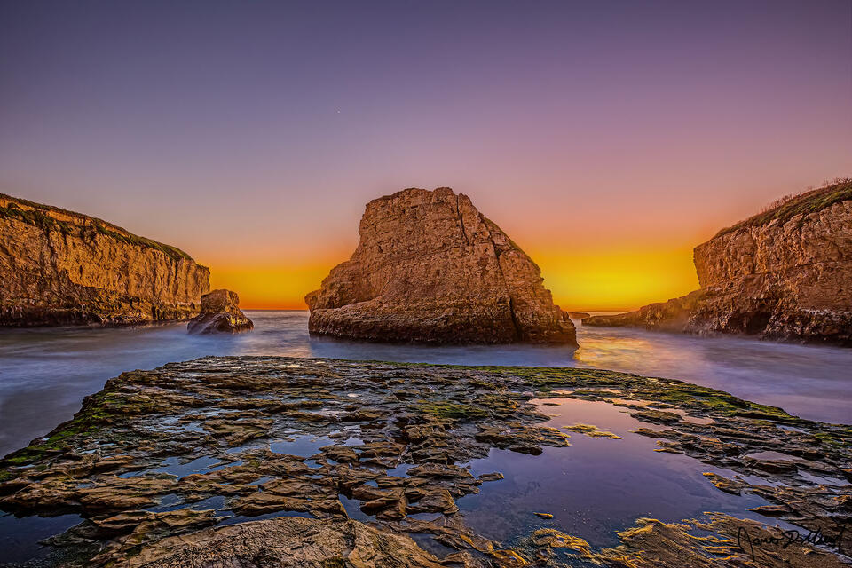 Sunset illuminates the skies over the Pacific Ocean and Shark Fin Cove as Venus shines brightly above.