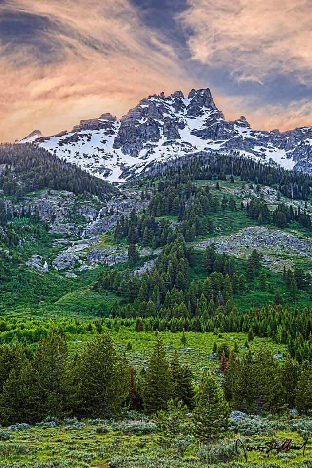 Golden hour illuminate skies above Teewinot Mountain as Broken Falls tumbles 300 feet over seven tiers down the slopes towards Lupine Meadows below.