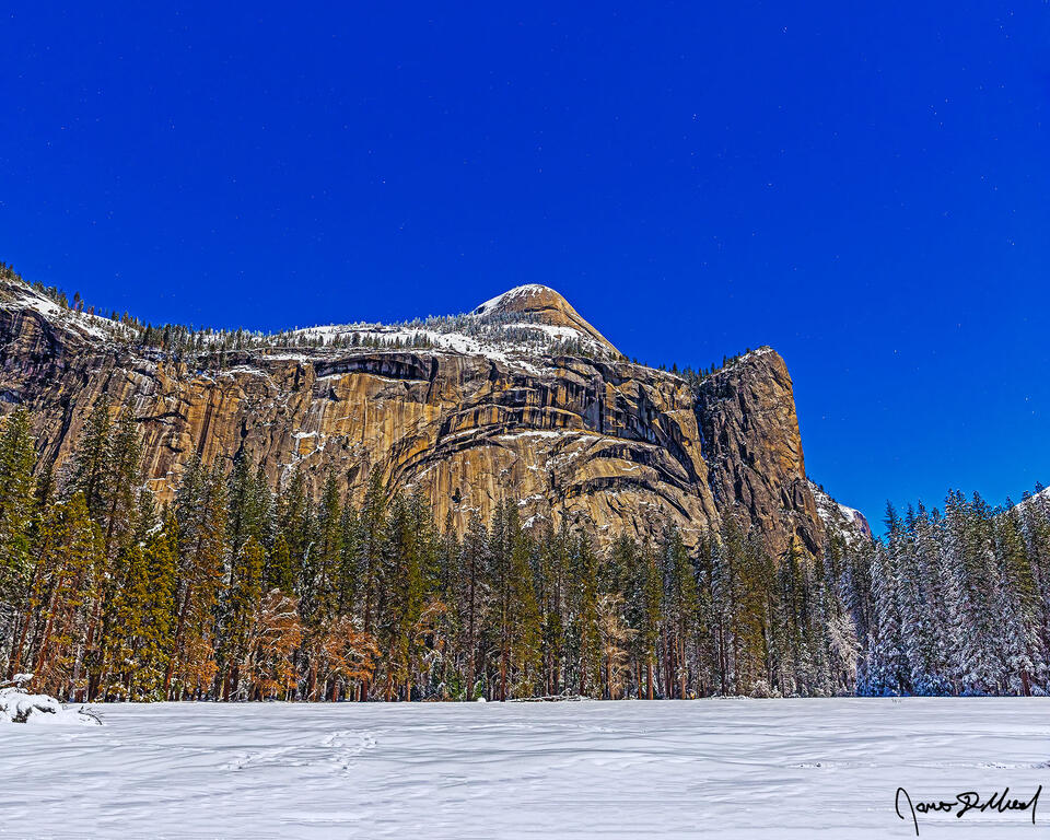 Moonlight illuminates North Dome, Royal Arches, Royal Arch Cascades, Washington Column above snow covered Stoneman Meadow and Yosemite Valley.