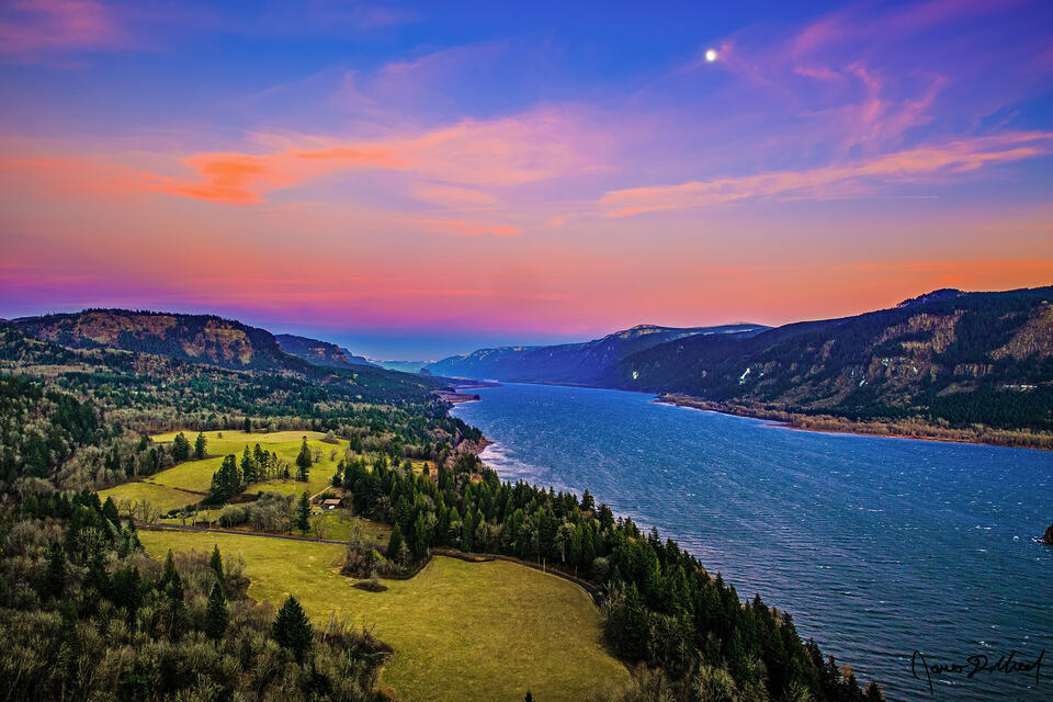 The first sunset of the year brings the pastel colors of the Belt of Venus to the skies above the Columbia River as the moon rises into the evening sky.