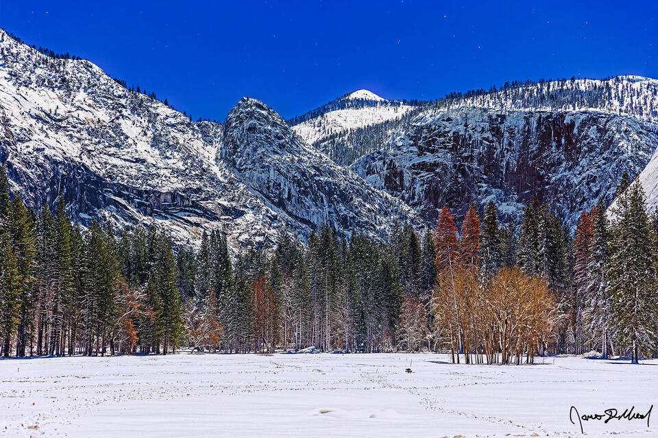 Moonlight illuminates Grizzly Peak (middle) and Mount Star King (right) as snow blankets Ahwahnee Meadow and Yosemite Valley.