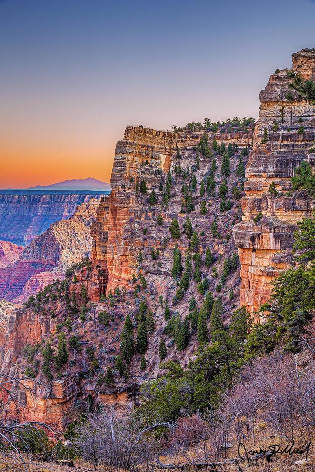 Sunset brings color to the skies above Angels Window, the Palisades of the Desert and Vishnu Temple in Grand Canyon National Park as San Francisco Peaks rise up