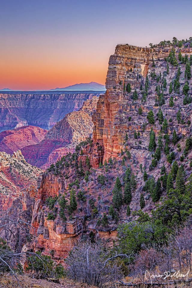 Sunset brings color to the skies above Angels Window, the Palisades of the Desert and Vishnu Temple in Grand Canyon National Park as San Francisco Peaks rise up