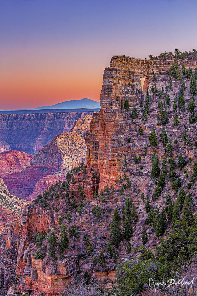Sunset brings color to the skies above Angels Window, the Palisades of the Desert and Vishnu Temple in Grand Canyon National Park as San Francisco Peaks rise up