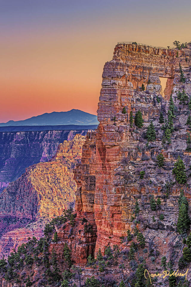 Sunset brings color to the skies above Angels Window, the Palisades of the Desert and Vishnu Temple in Grand Canyon National Park as San Francisco Peaks rise up