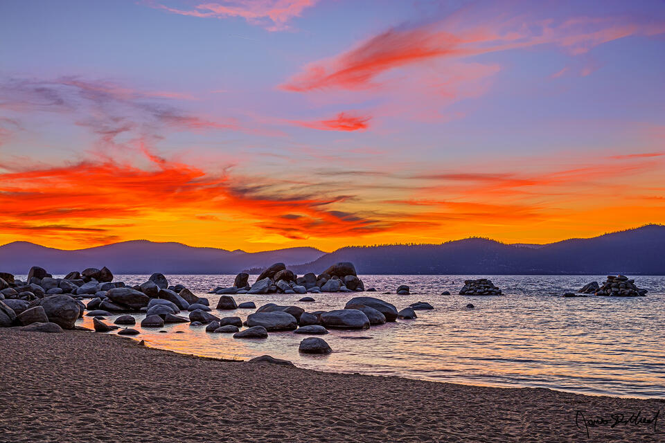 Sunset above Lake Tahoe and Sand Harbor lights the skies with an amazing display of colors as the warm glow of the setting sun reflects on the waters below.