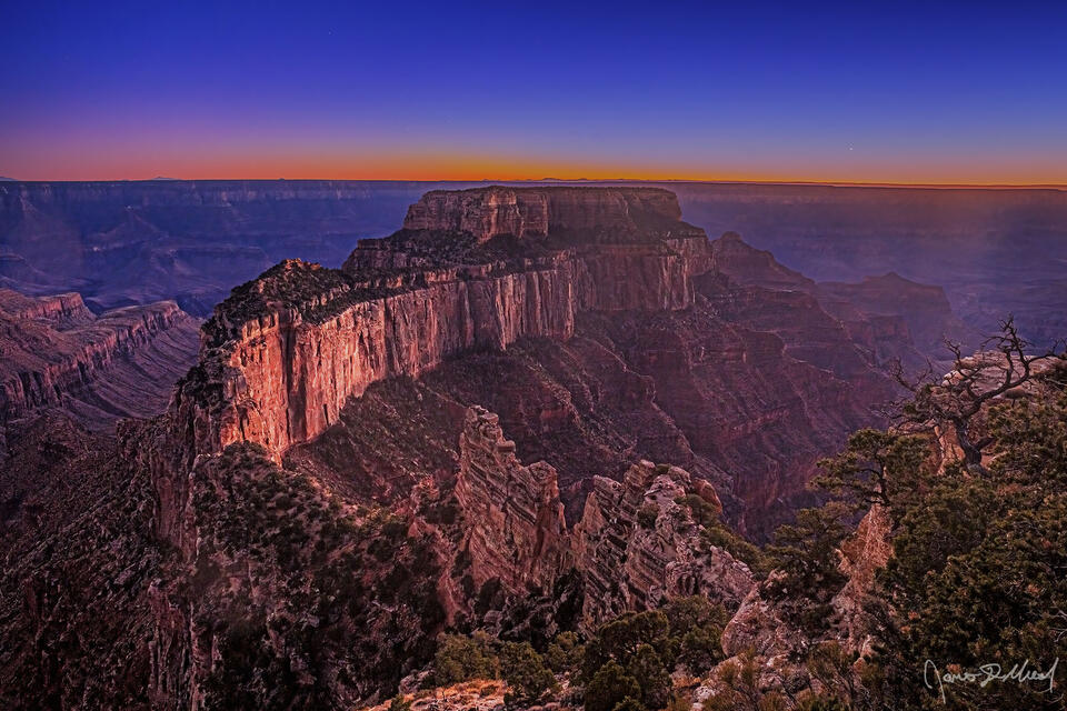 Soft pastel colors illuminate the horizon as Nautical Twilight sets in over Wotans Throne, Cape Royal and the Grand Canyon.