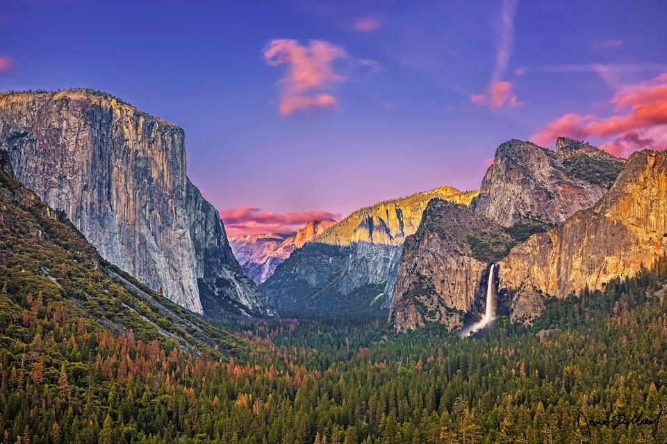 Sunset illuminates the granite cliffs above Yosemite Valley with a golden hue as Bridalveil Fall tumbles 620 feet over the cliffs and into the valley below.