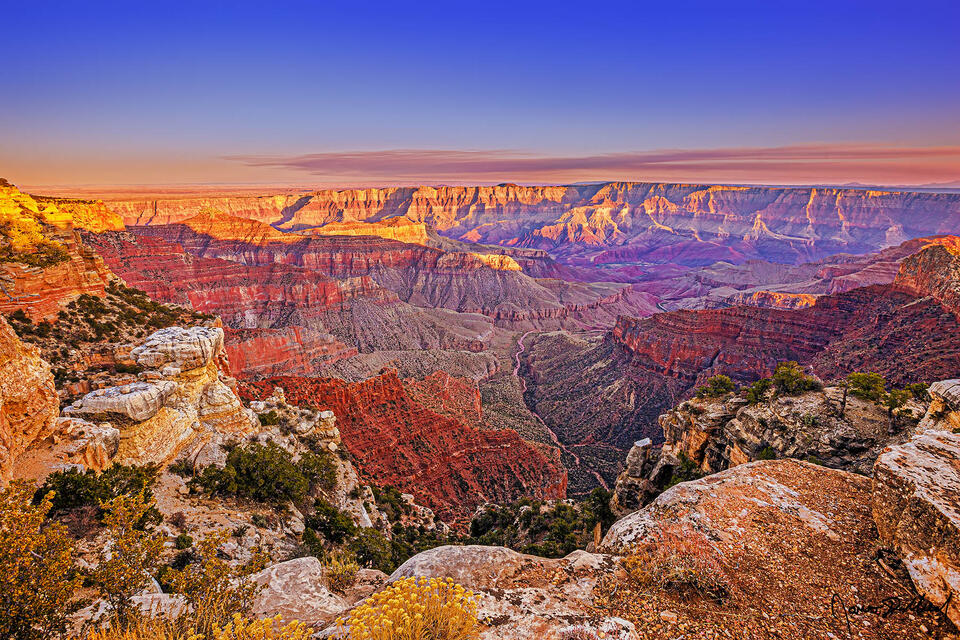 Sunset casts a glow onto Jupiter Temple, Venus Temple, Apollo Temple, Cape Final and the Palisades of the Desert as pastel colors begin to show above.