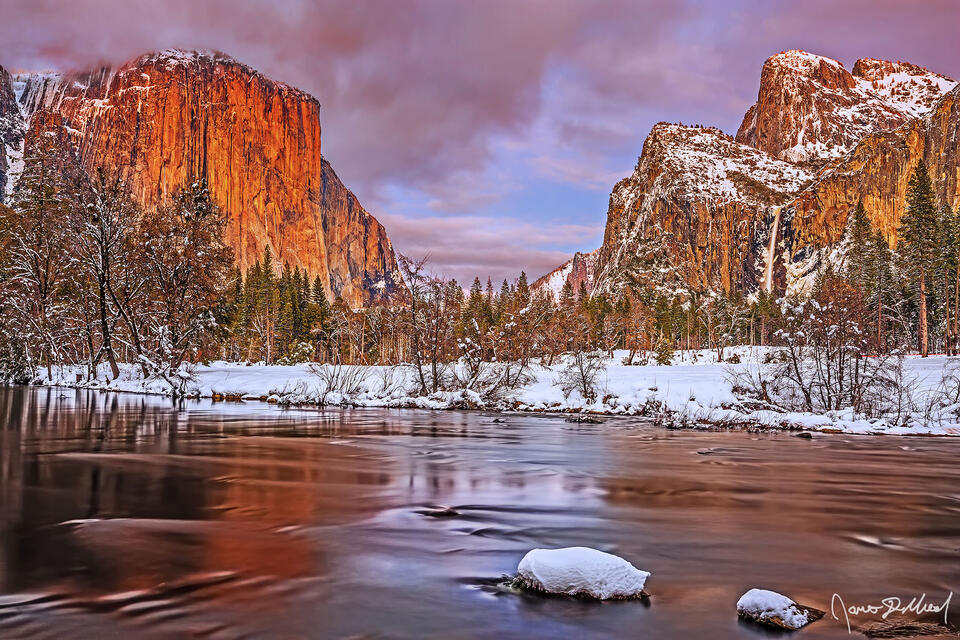 Alpenglow after sunset illuminates the face of El Capitan a fiery orange, as soft light illuminates Cathedral Rocks, Bridalveil Fall and the Merced River.