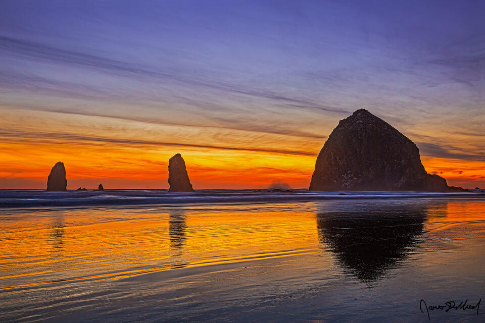 Long after sunset, color hang on in the skies over Haystack Rock, The Needles and the Pacific Ocean in Cannon Beach Oregon as as Dusk nears.