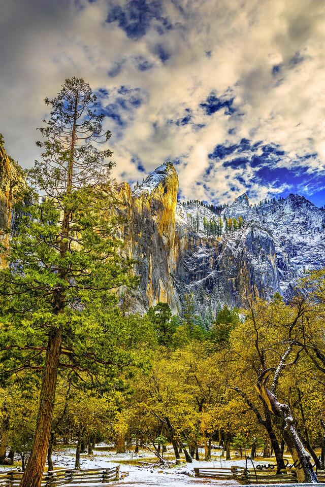 The Leaning Tower glows at sunset as it rises high above Yosemite Valley as the first snow of late fall covers the valley floor and the granite cliffs above.