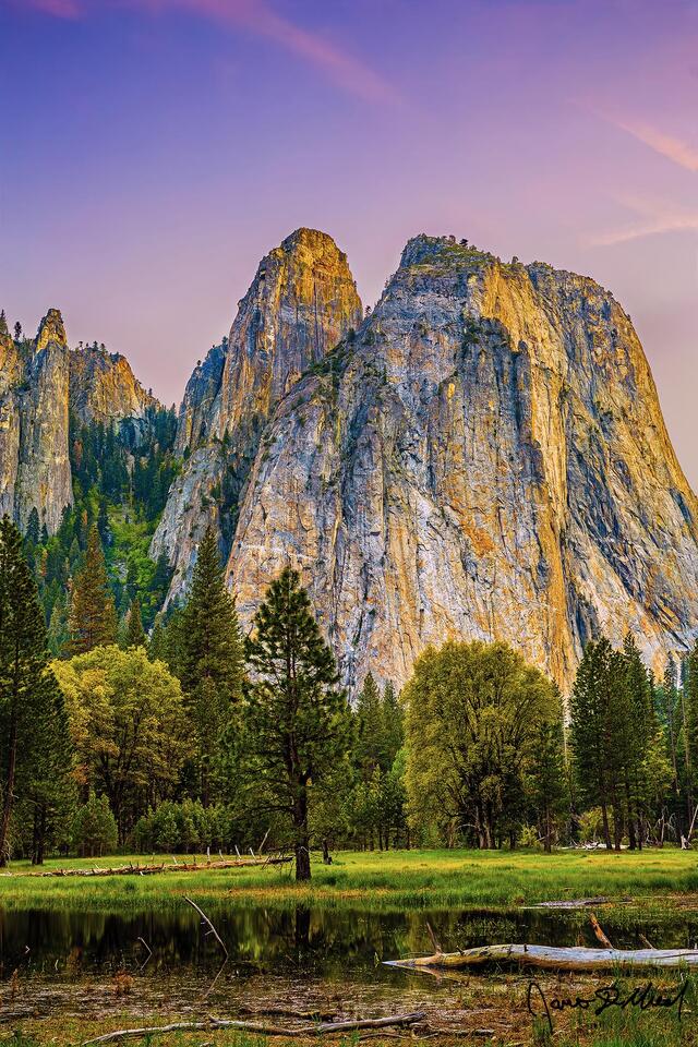Alpenglow at sunset above Yosemite Valley and Wosky Pond as the peaks of Cathedral Rocks and Cathedral Spires get bathed in warm light.