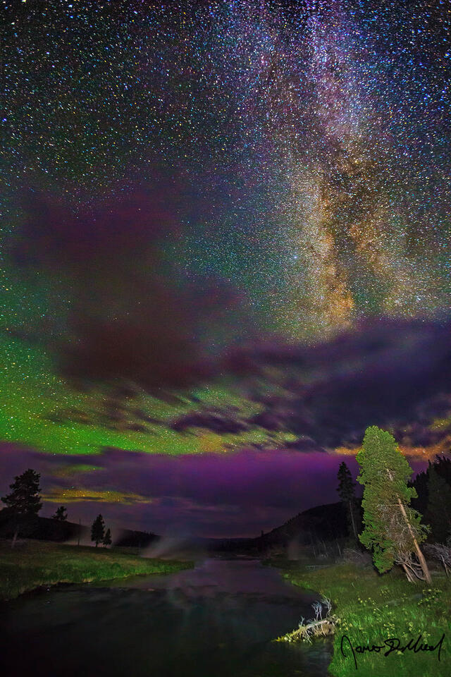The Milky Way Core rises above the clouds and into the sky above the Firehole River in Yellowstone National Park