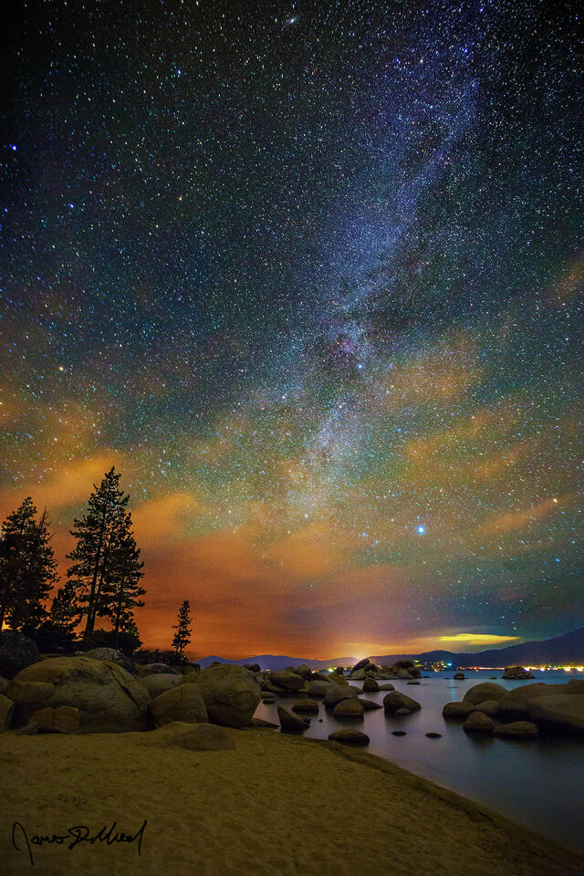 The Milky Way rises above the clouds on the Horizon and into the night sky high above the shores of Sand Harbor on Lake Tahoe