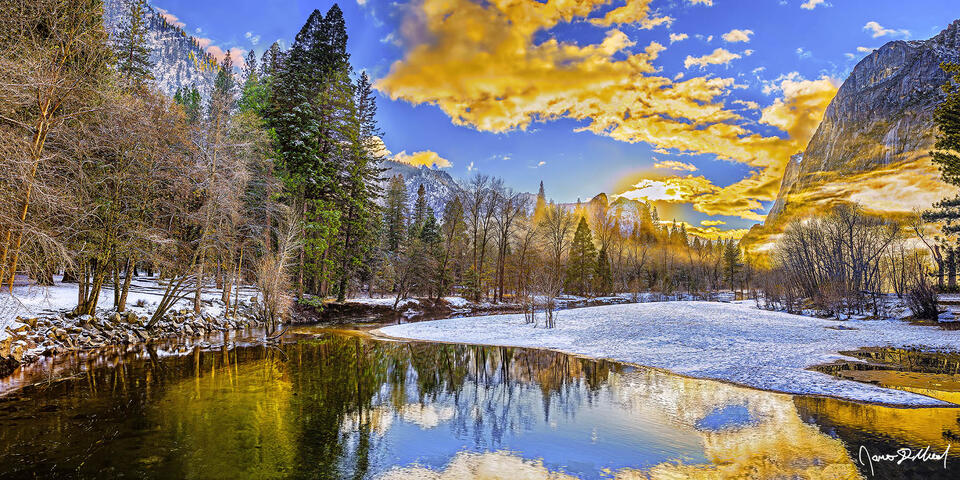 Sunset lights the skies above Lower Brother, Cathedral Rocks and snow covered Yosemite Valley as fog and mist rise from the snowy banks of the Merced River