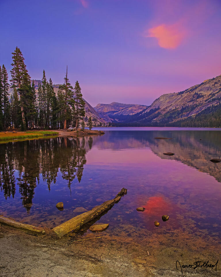 Alpenglow lights the skies above as Polly Dome, Pywiack Dome, Mariuolumne Dome, Medlicott Dome and Dozier Dome, as they reflect in the waters of Tenaya Lake.