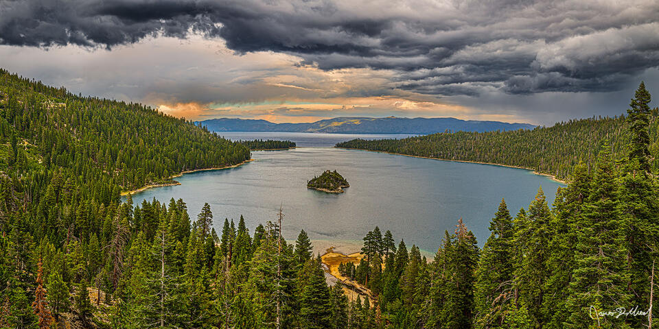 Storm clouds roll in over Lake Tahoe and Emerald bay. The light of sunset transitions to darkness as the storm clouds overtake the skies above, dropping rain.