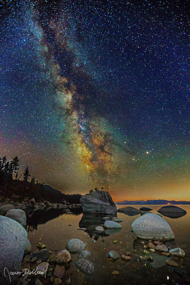 The Milky Way rises above Bonsai Rock and the still reflections in the waters of Lake Tahoe.