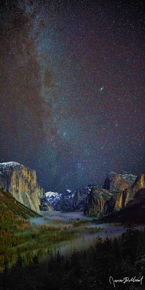 The winter spiral arm of the Milky Way stretches high into the sky over El Capitan, Cathedral Rocks and Yosemite Valley as fog fills the valley below.