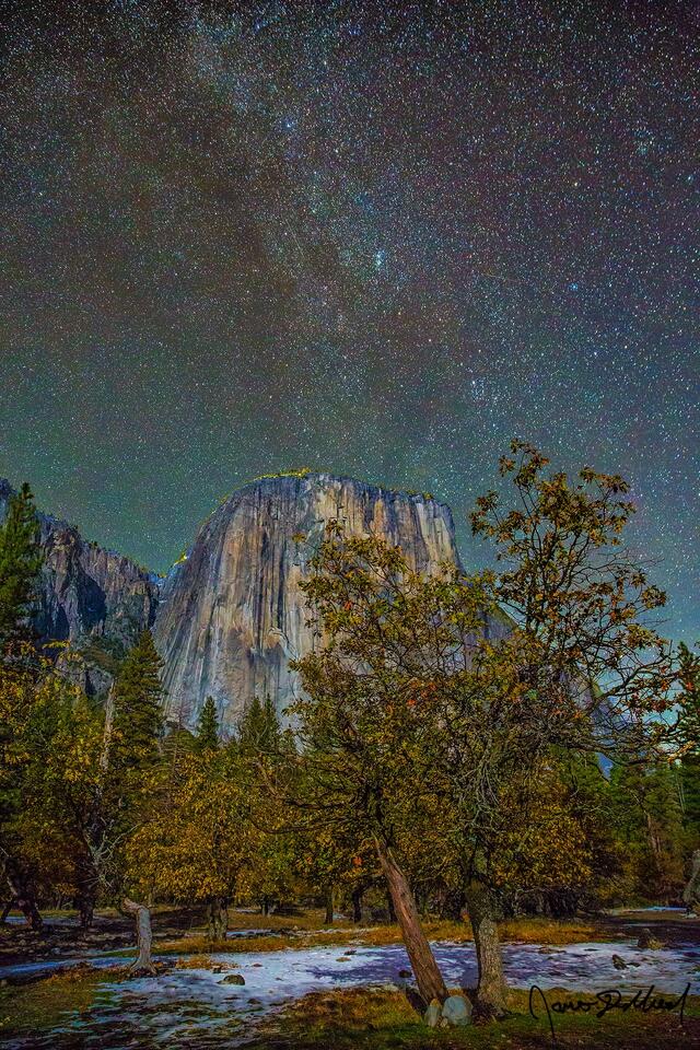 The winter  Winter Milky Way rises into the sky above El Capitan as the first snow of winter begins to cover the Dogwood Tree lined meadows of Yosemite Valley.