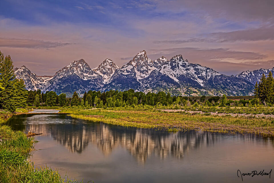 Sunrise over the Cathedral Group as the scene reflects in the still waters of a Beaver Pond along the Snake River in Grand Teton National Park