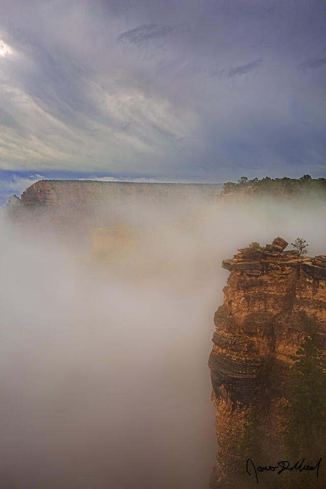 A temperature inversion (full thermal inversion, total cloud inversion) creates a rare sight as clouds fill the Grand Canyon while storm clouds line the skies.