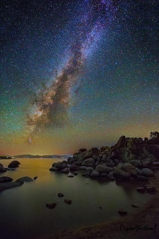 The Milky Way rises high above a rocky outcropping on the shores of Lake Tahoe in Nevada