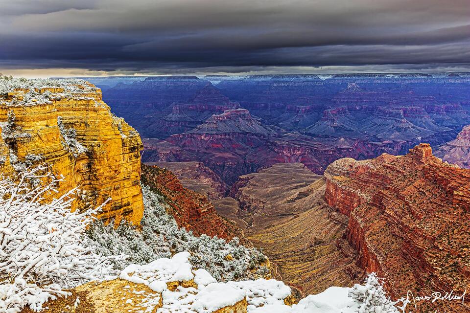 Storm clouds darken the skies above the Grand Canyon as the South Rim and North Rim lay covered in snow.