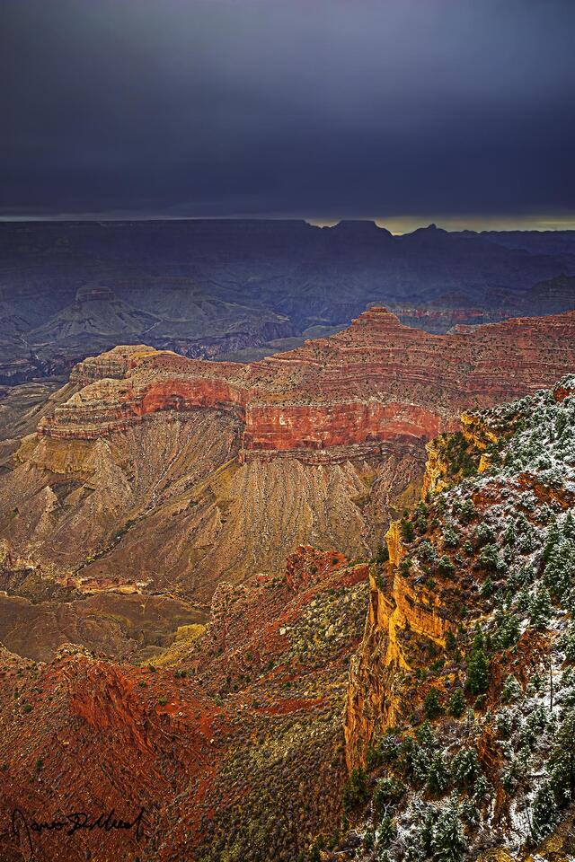 Storm clouds darken above the skies above Wotans Throne and Vishnu Temple almost 10 miles away as snow begins to fall at O'Neill Butte and the South Rim.