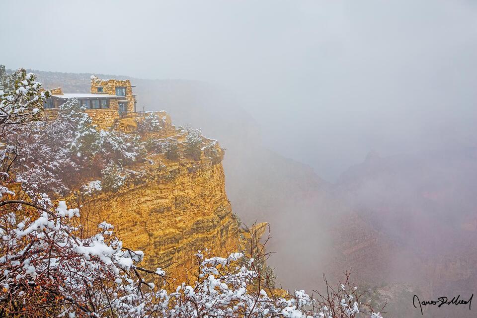 Snow lines the top of the Grand Canyon during a winter storm as a temperature inversion begins to obscure the canyon below.