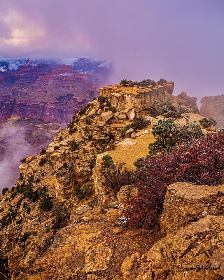 A partial thermal inversion begins to form in the Grand Canyon as sun shines through a spot in the clouds above at sunset.