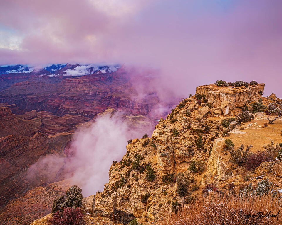 A partial thermal inversion begins to form in the Grand Canyon as sun shines through a spot in the clouds above at sunset.