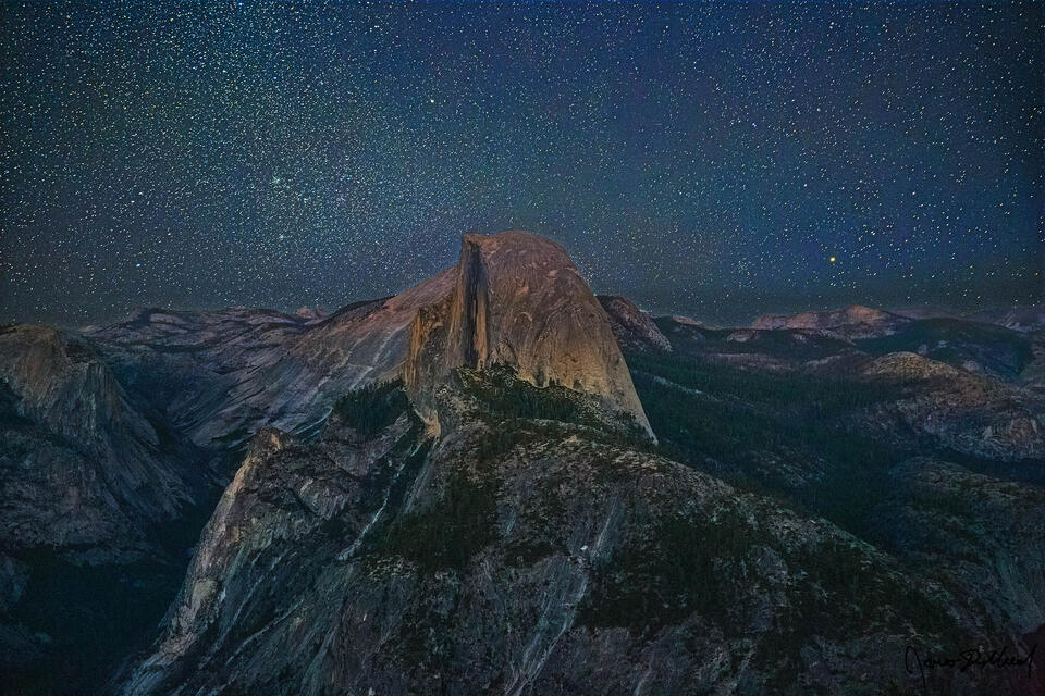 The stars and the night sky rise overhead above Half Dome as Astronomical Twilight sets in and the dark of night draws near.