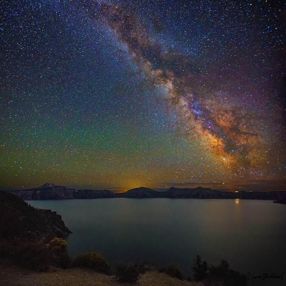 The Milky Way rises high into the night sky above Pumice Point and Crater Lake as faint airglow illuminates the skies above.