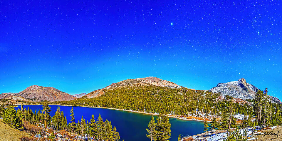 Snow begins to cover the shoreline around Tioga Lake in mid-November as Tioga Peak, Dana Plateau, and Mount Dana rise above it, illuminated by the full moon