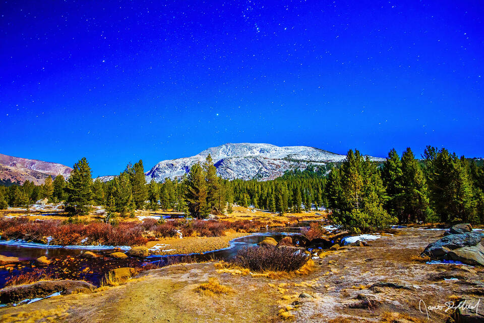 Mammoth Peak and the Tuolumne River are illuminated by the full moon and the starry sky up in the Yosemite High Country in mid November.