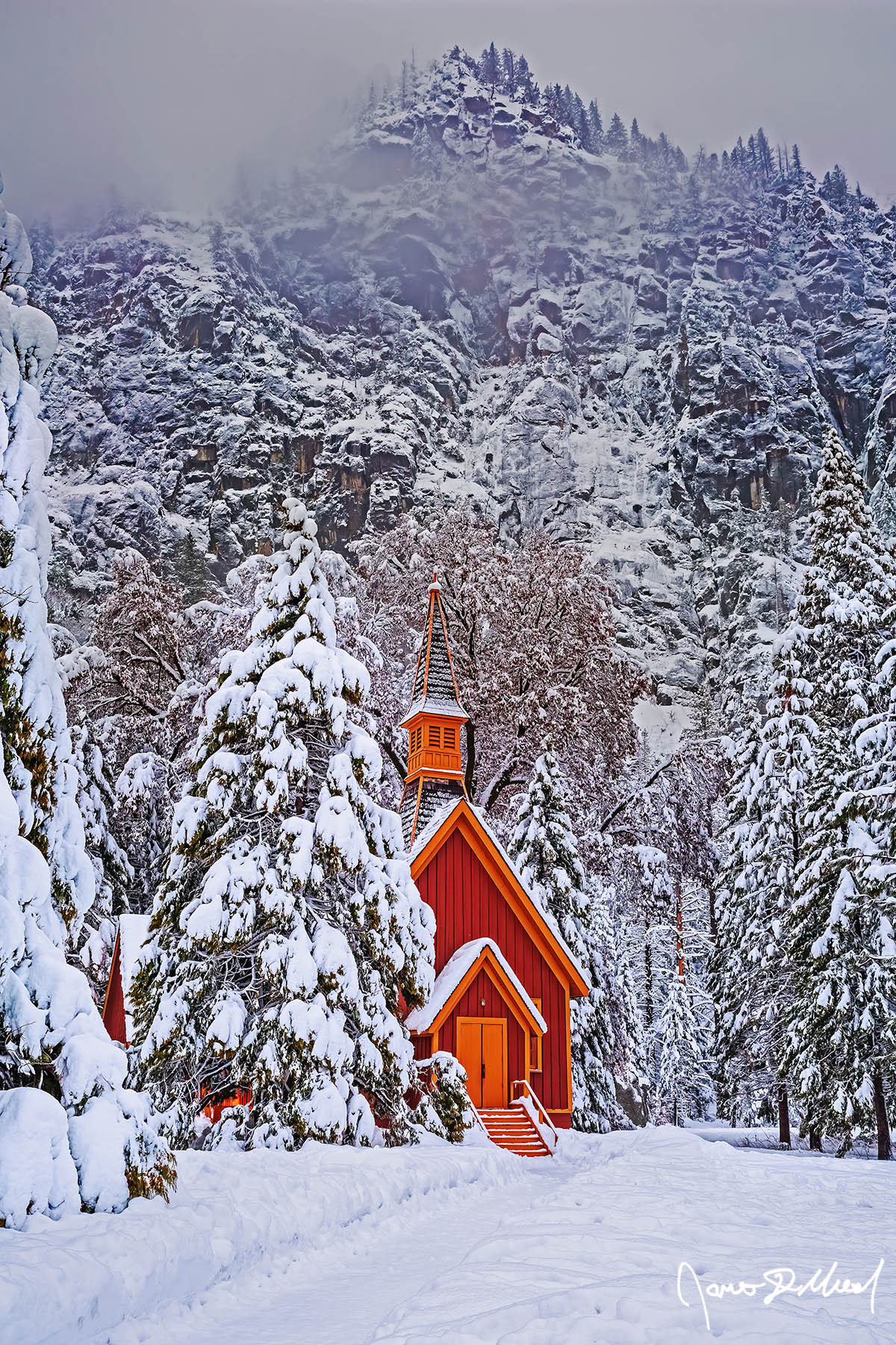 Winter Hideaway Snow blankets the Yosemite Valley Chapel, the surrounding trees and meadow at dusk as fog clings to the snow-covered granite cliffs rising above Yosemite Valley