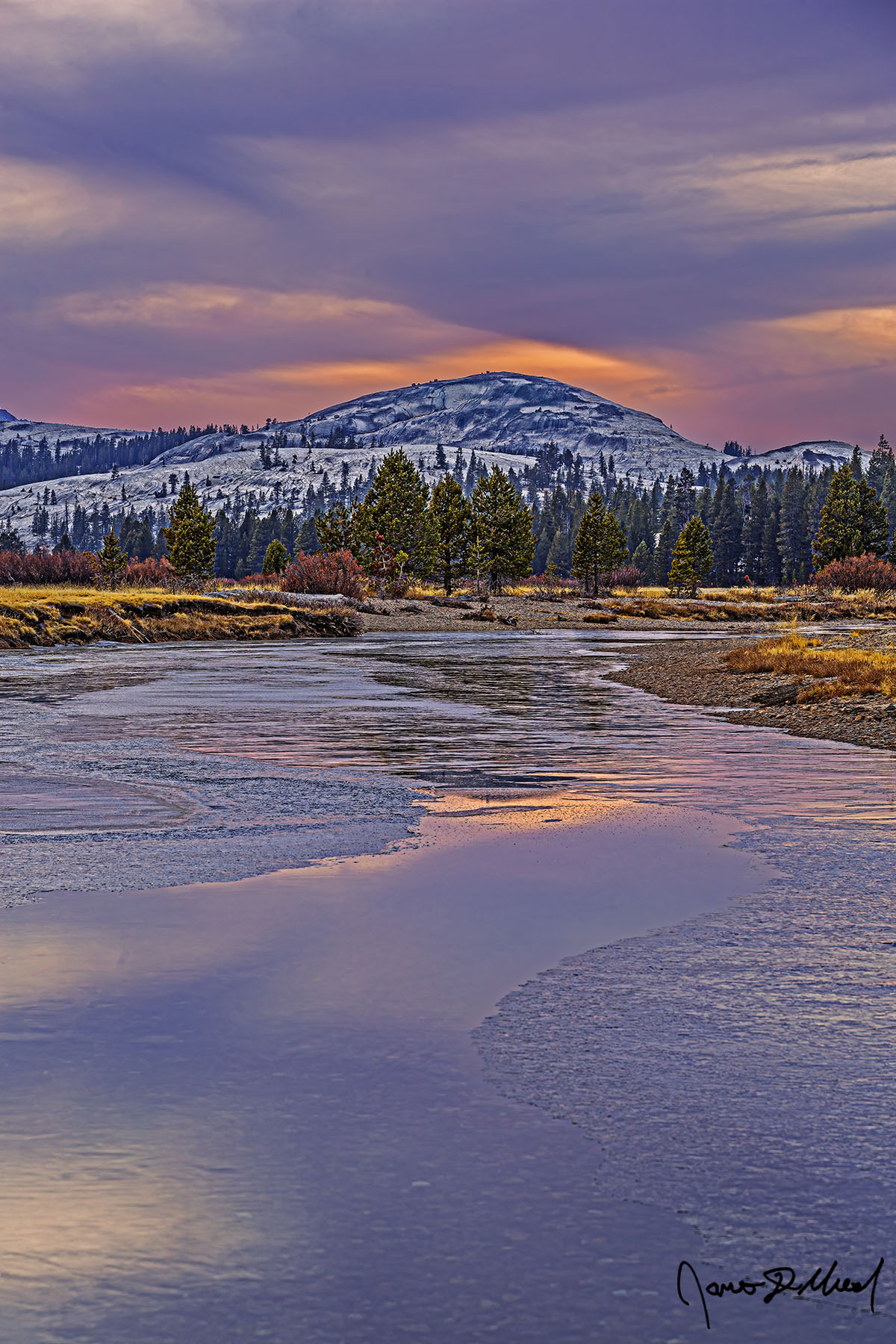 Frozen Fairytail Sunset lights the skies above Pothole Dome, as the colors reflect in the waters of the Tuolumne River as it begins to freeze over for the winter.