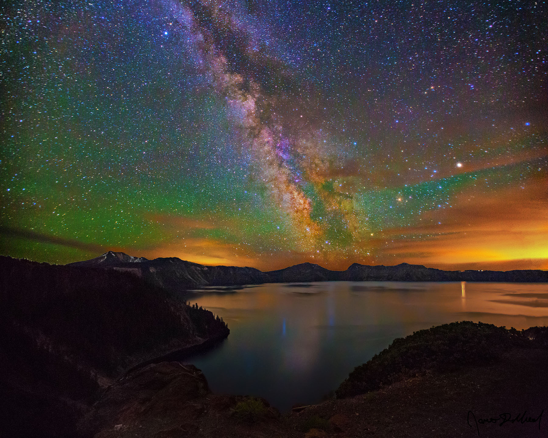 Glimmering Magic - Milky Way Reflecting in Cleetwood Cove and Crater Lake with Vivid Diffuse Aurora The sky illuminates green from diffuse aurora as the Milky Way core rises over Cleatwood Cove, reflecting in Crater Lake at Crater Lake National Park.