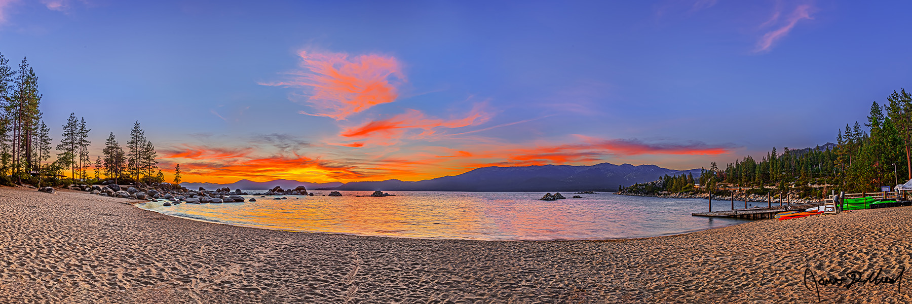 Sun-kissed Reflections - Sand Harbor Sunset Reflection in Lake Tahoe in the Sierra Nevada Sunset ignites the clouds along the above Sand Harbor with a brilliant display of color as the warm colors reflect in the waters of Lake Tahoe below.