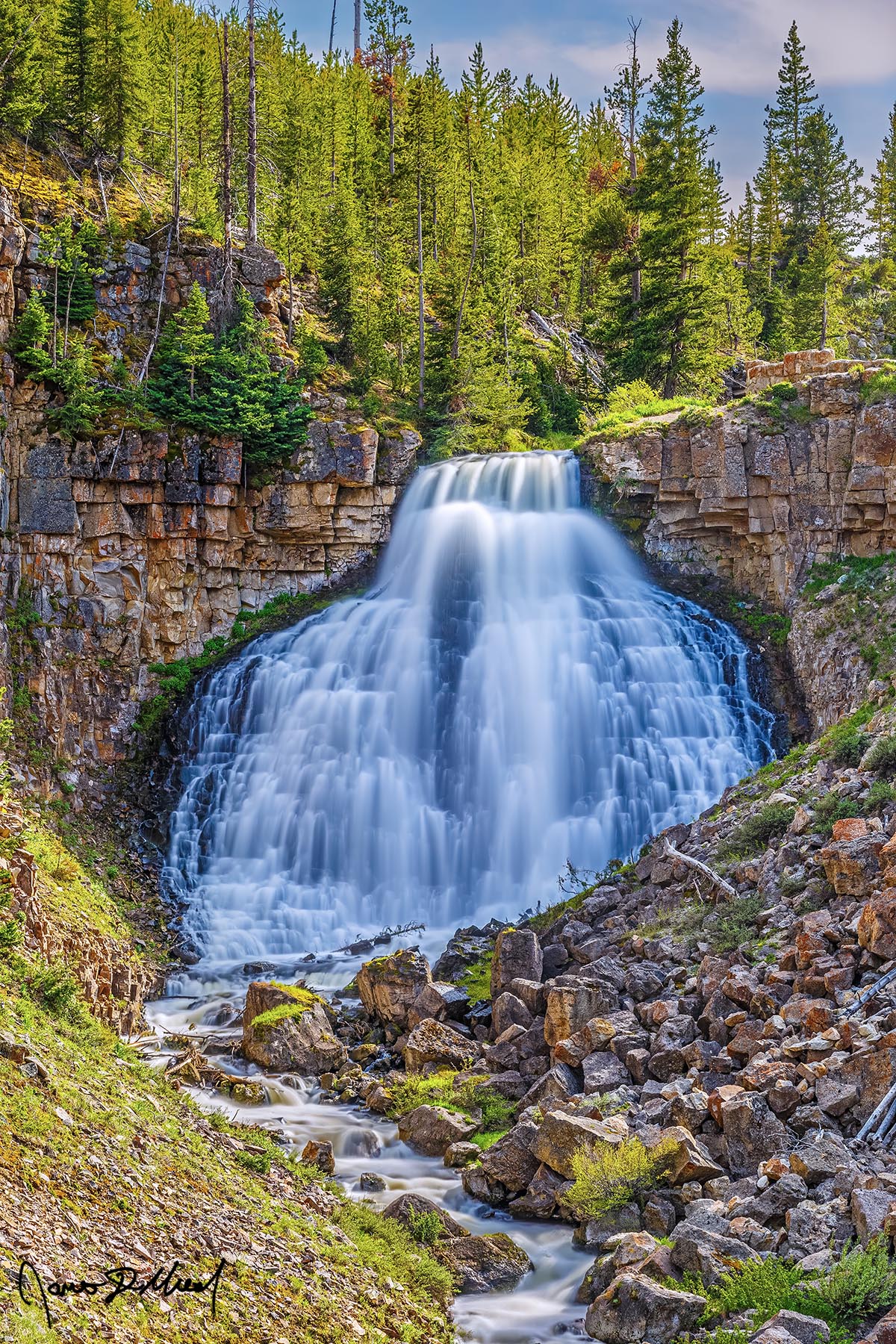 Weeping Wall Rustic Falls cascades 47 feet over columnar basalt cliffs in Yellowstone National Park during the spring melt.