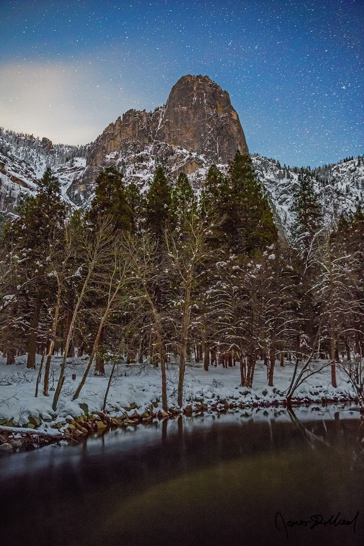 Winter’s Guard The rising moon begins to illuminate the night skies above Sentinel Dome and the Merced River as snow blankets the Yosemite Valley floor and granite cliffs.