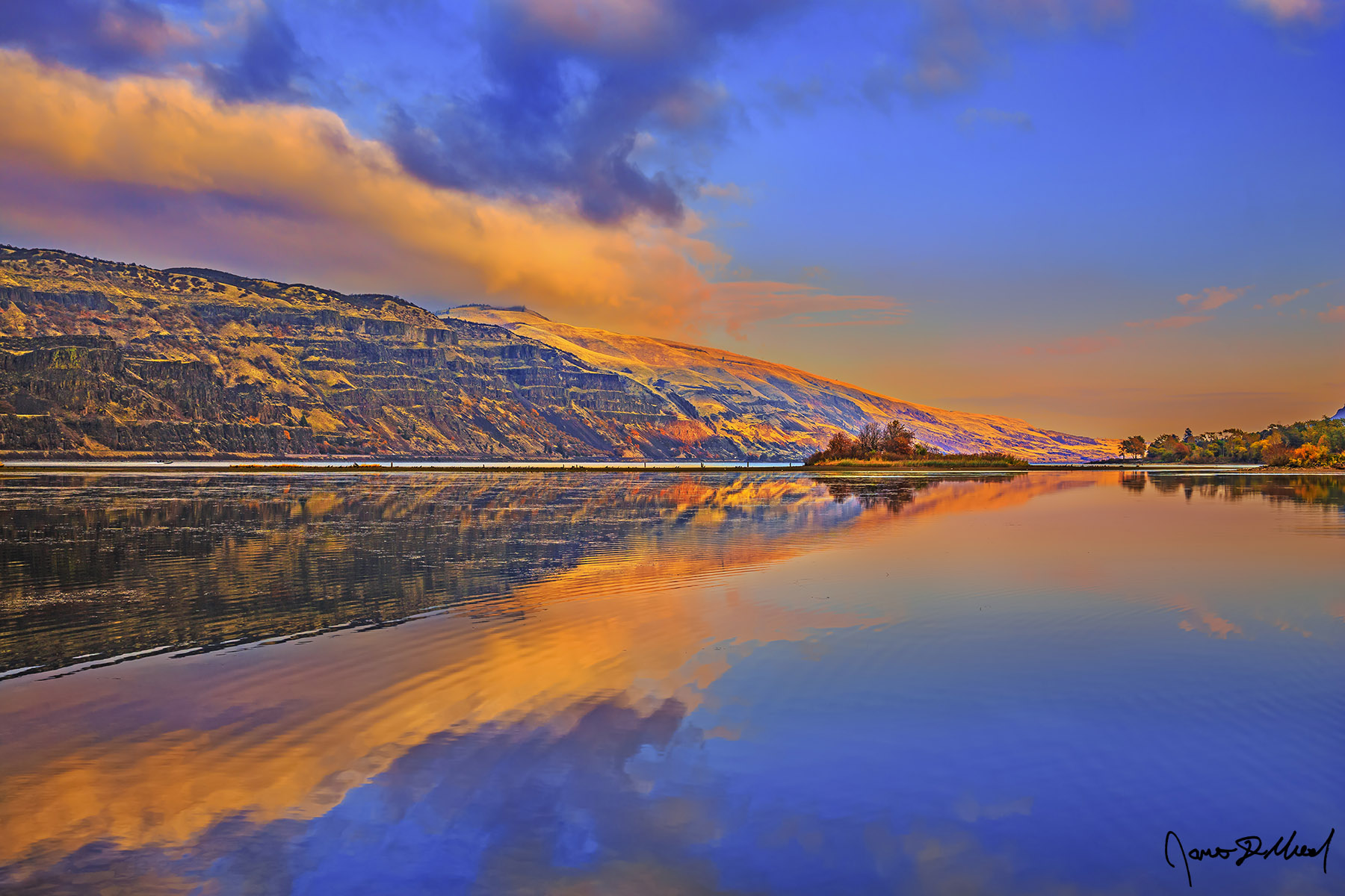 Columbia Reflection - Sunset Fall Color Mirror Reflections in the Columbia River Gorge, Oregon The still waters of the Columbia River create a mirror reflection while light from the Golden Hour illuminates the skies at sunset.