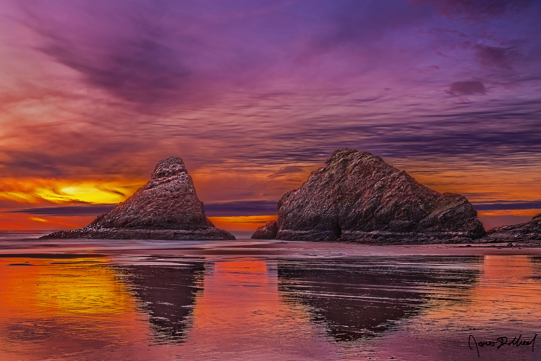 Fire on the Water The warm colors of the sunset reflect off the wet sand like fire on the water, while Sea Stacks rise up from the Cape Cove during a negative tide (minus tide).