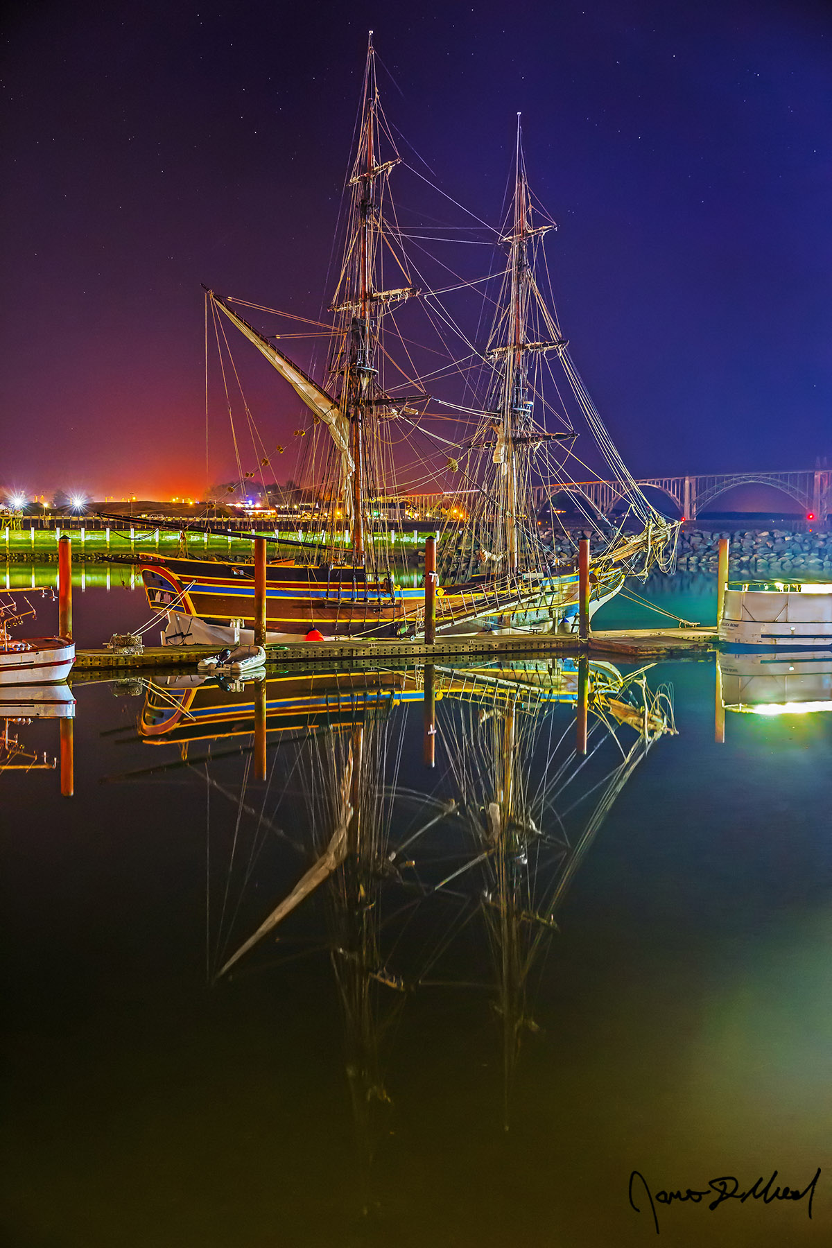 Ghost Ship The Lady Washington, a full-scale replica of the original Lady Washington from the time of the Revolutionary War, reflects in the still waters of Yaquina Bay.