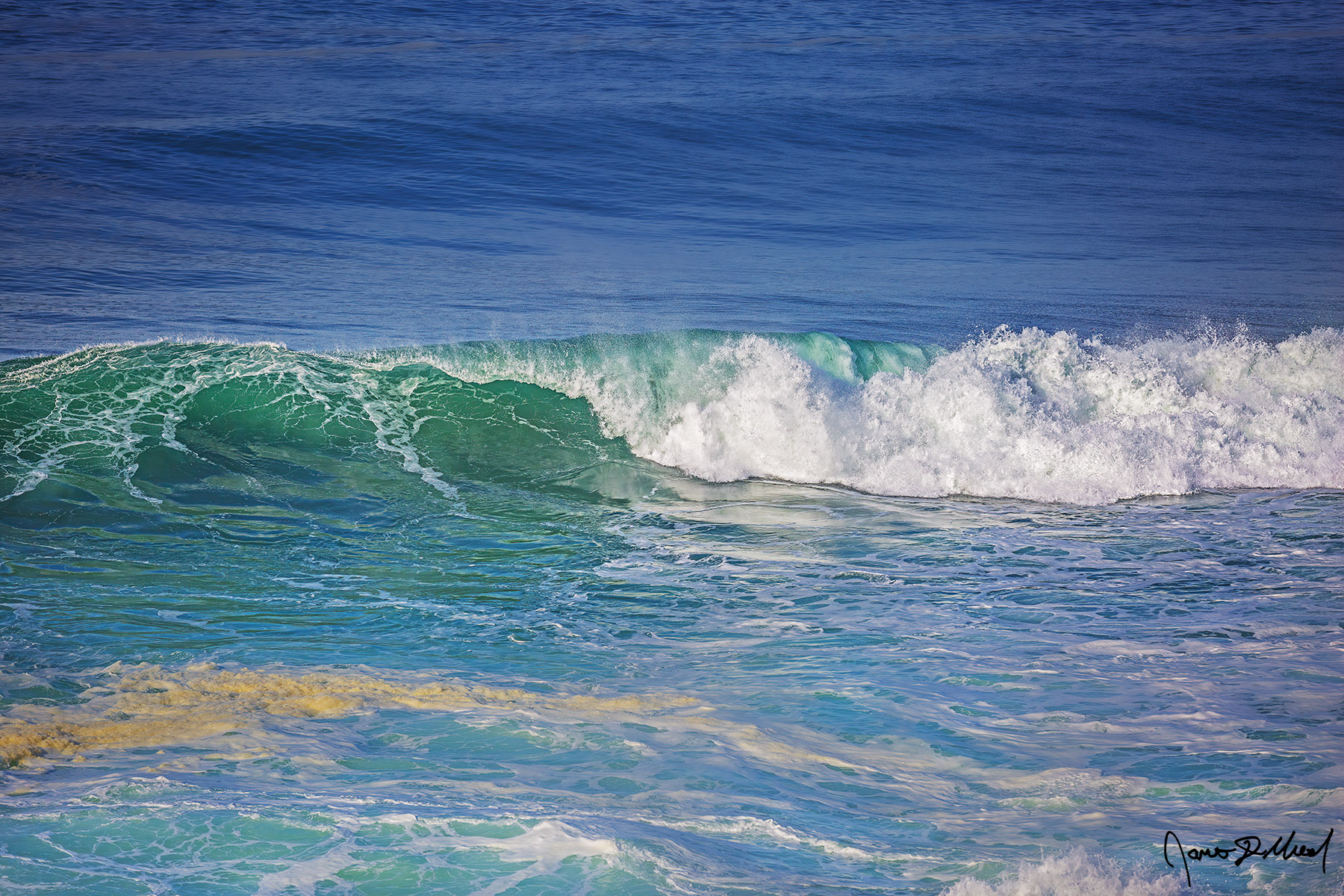 Emerald Roller Emerald Waves in the Pacific Ocean show a beautiful turquoise emerald color as sunlight illuminates the water in the waves when they crest.